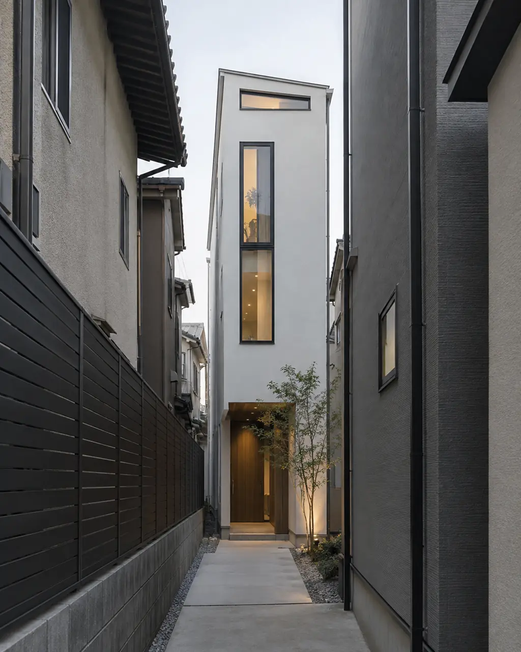 住宅が密集した旗竿地に建つ細長い3階建ての住宅