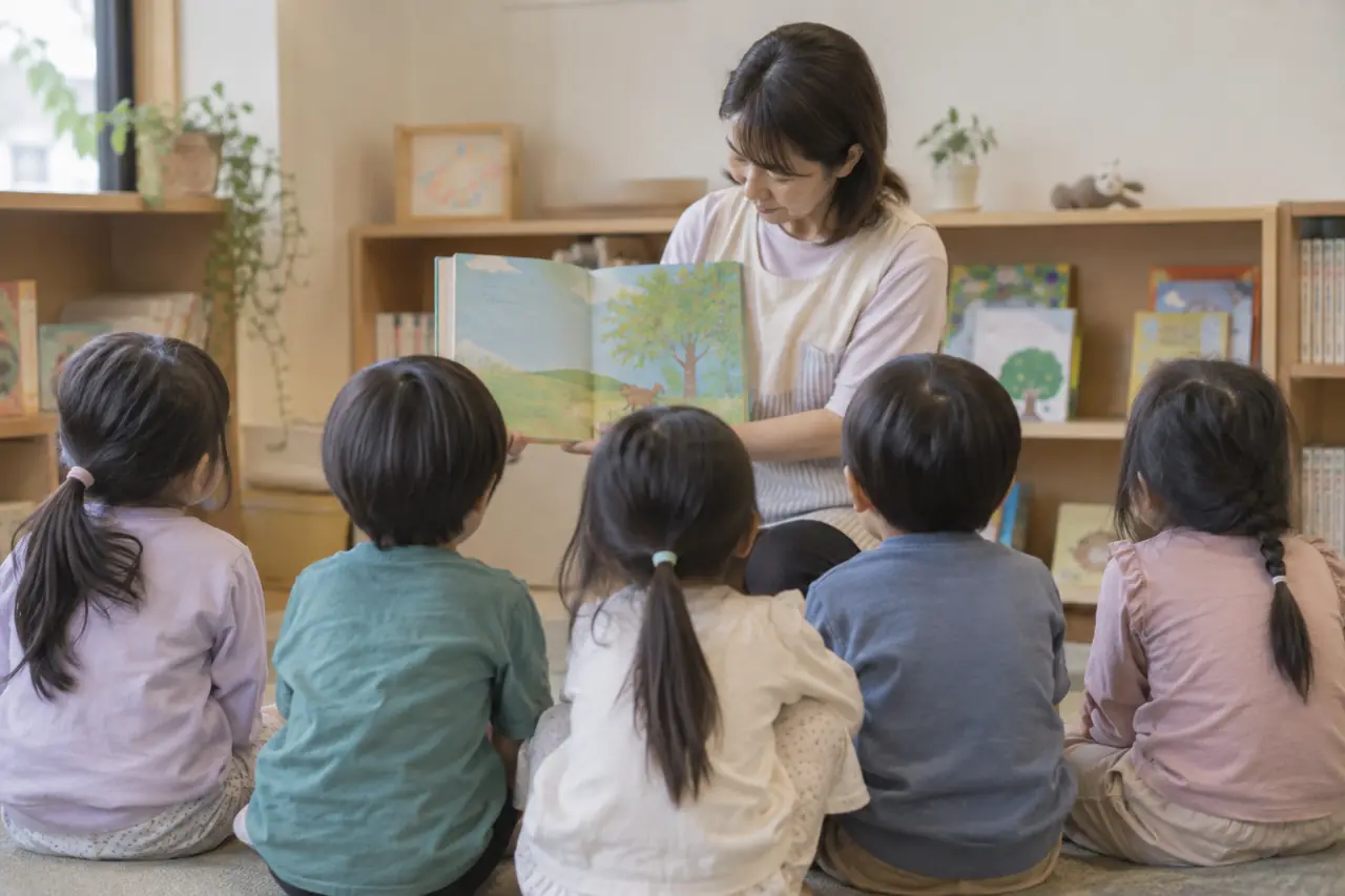 絵本の読み聞かせを聞く子どもたちの後ろ姿