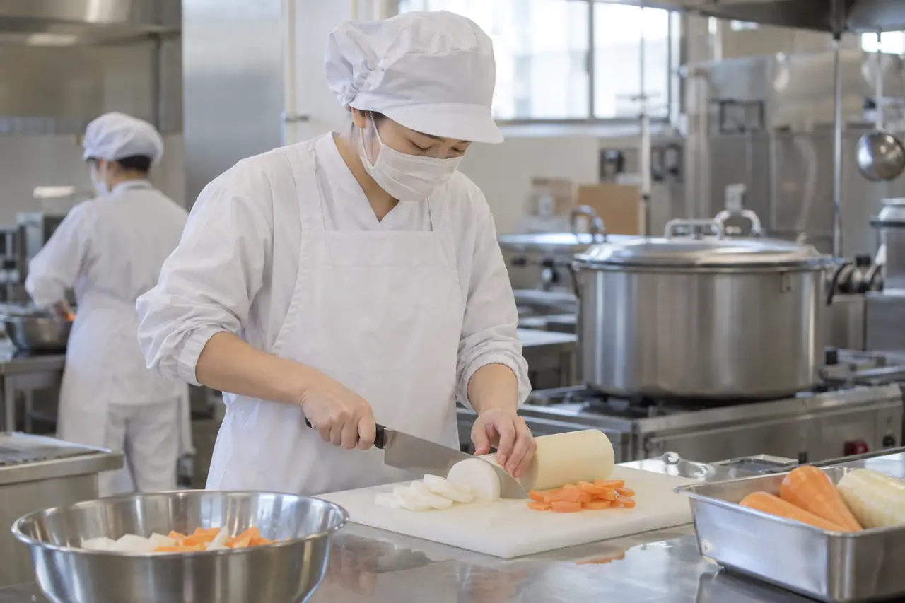 調理室で野菜を切る調理員の手元
