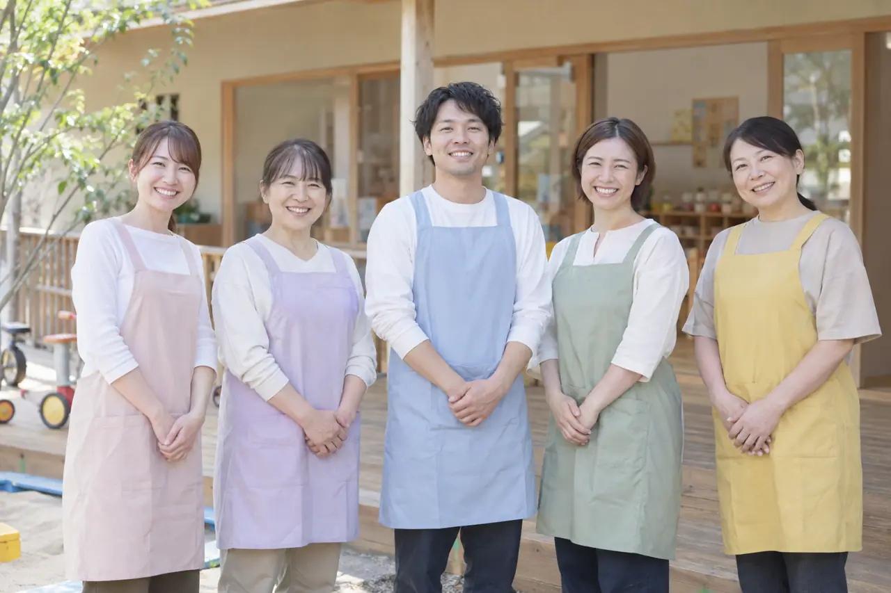 園舎のウッドデッキの前に並ぶ保育者たち