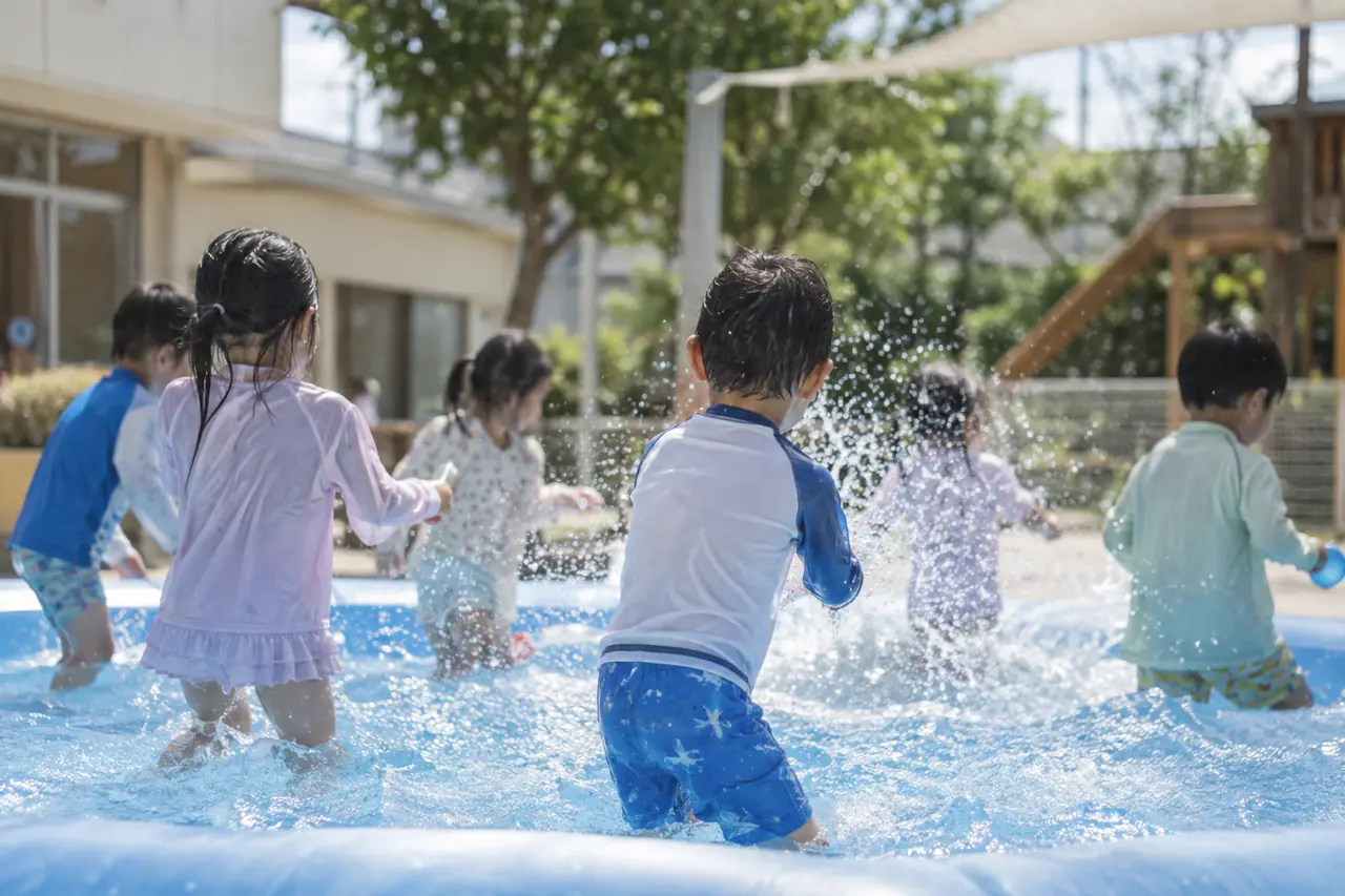 ビニールプールで水あそびをする子どもたち