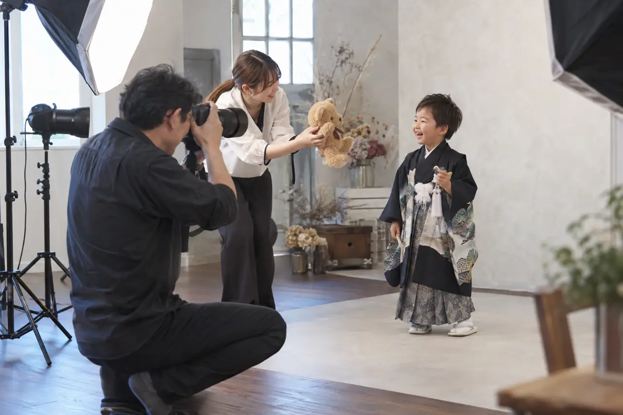 アシスタントが子どもを笑わせながら撮影する様子